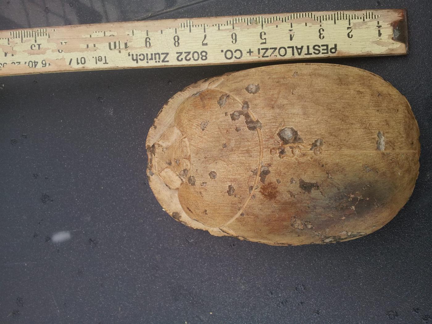 Skarabäus-Artefakt neben Zollstock — rund zehn Zentimeter