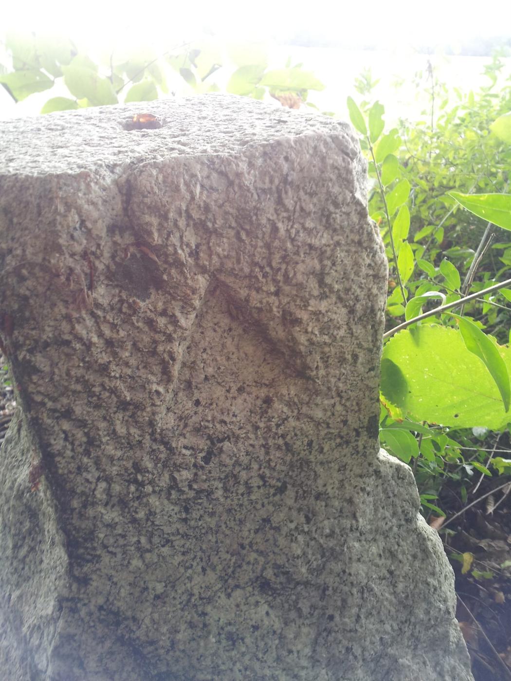 Behauener Granit-Markstein mit Loch und Pfeilkerbe